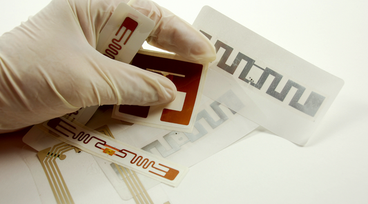 Gloved hand holding RFID chips and tags