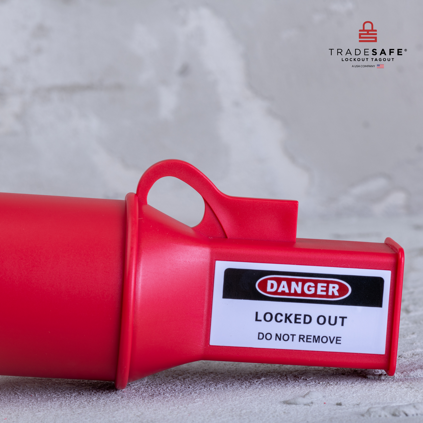 eye-level side view of a pin & sleeve socket lockout device lying down on a concrete floor