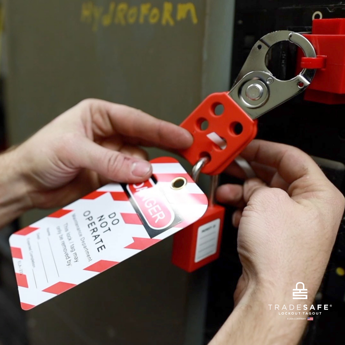 a loto tag in-use along with a loto lock and a steel hasp for a hydroforming machine