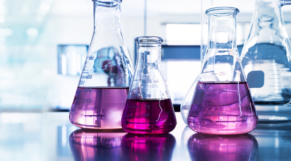 different sizes of Erlenmeyer flasks containing pink liquid