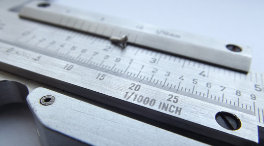 A metal measurement tool with calibrated markings and a sleek metallic finish