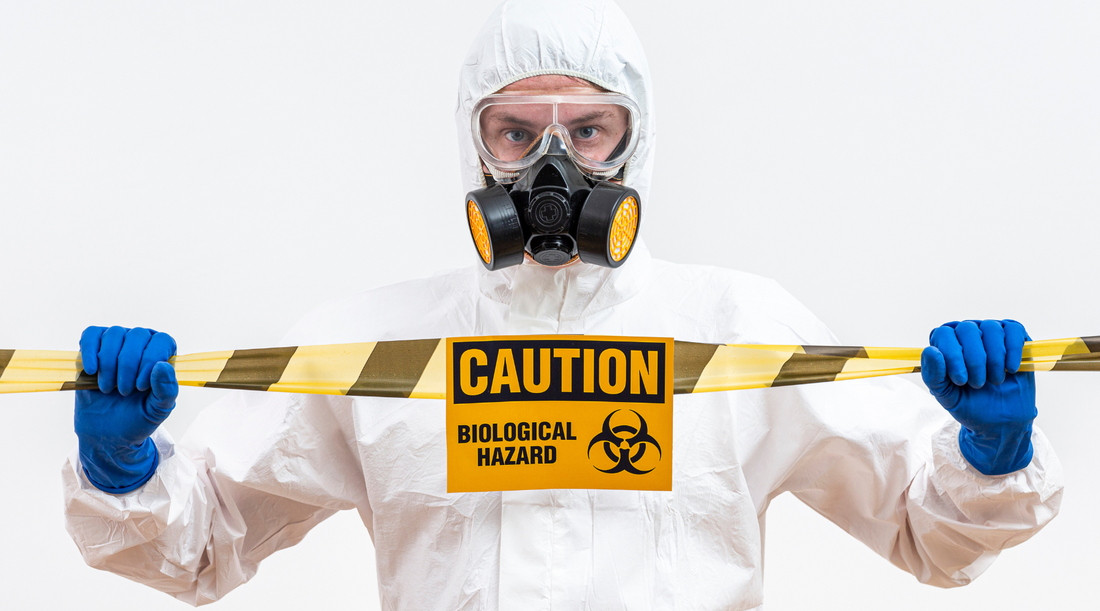 hazmat employee holding Caution: Biological Hazard Signage
