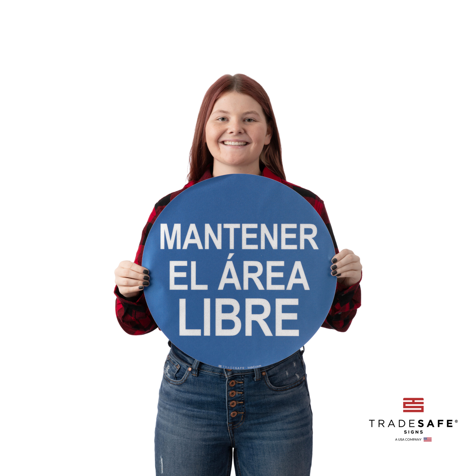 a person holding an adhesive vinyl sign with the text "keep area clear" in spanish