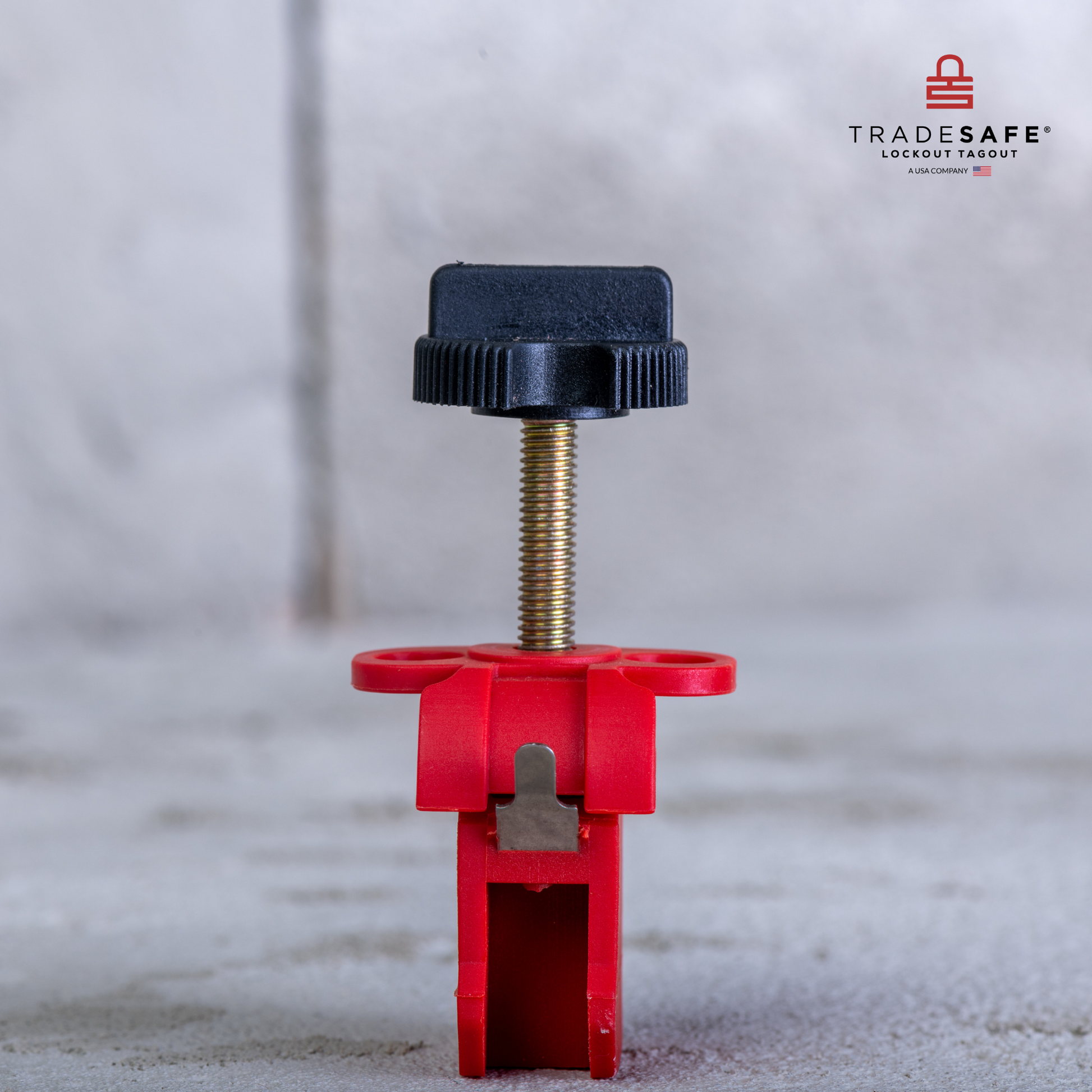 eye-level view of a tie bar miniature circuit breaker lockout with a concrete wall and floor background