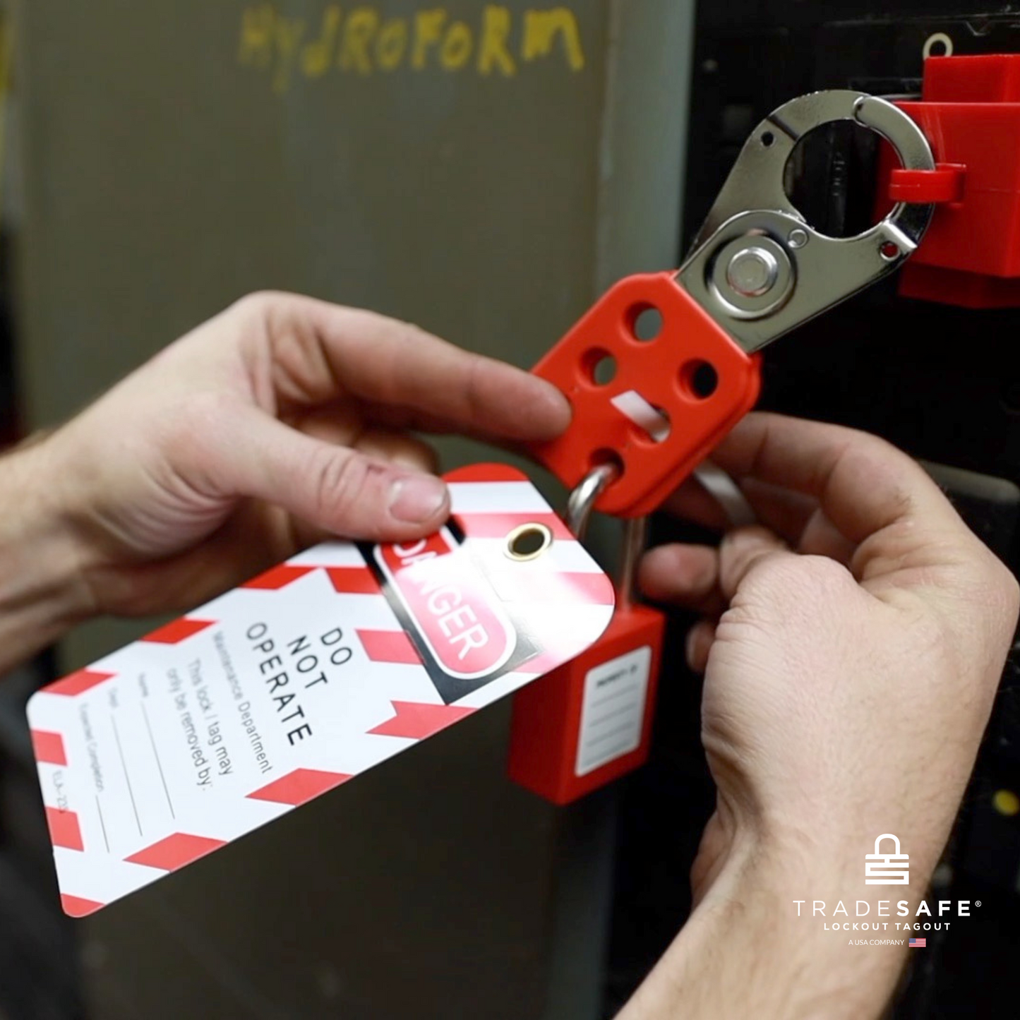 a loto tag in-use along with a loto lock and a steel hasp for a hydroforming machine 