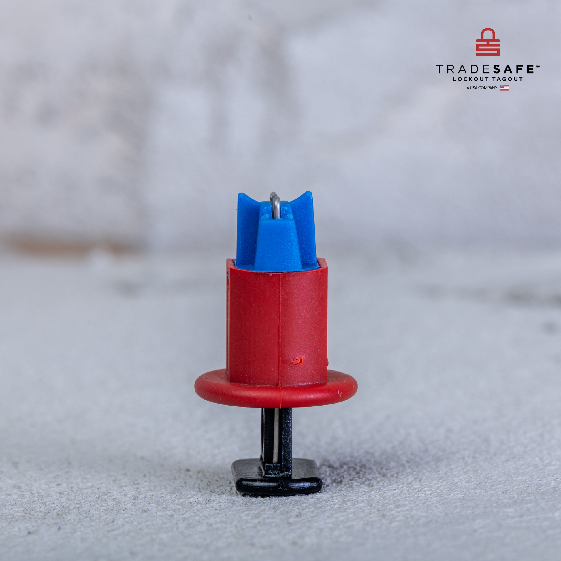 side view of a standing pin in standard miniature circuit breaker lockout with a concrete wall and floor background