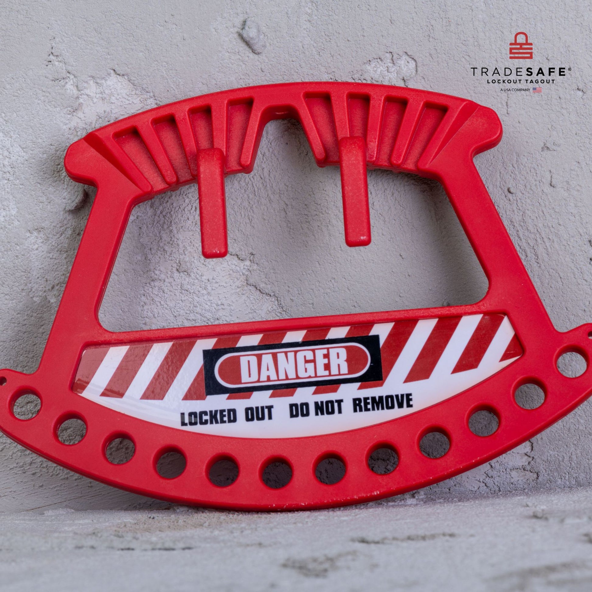 front view of a red portable loto padlock leaning on concrete wall background