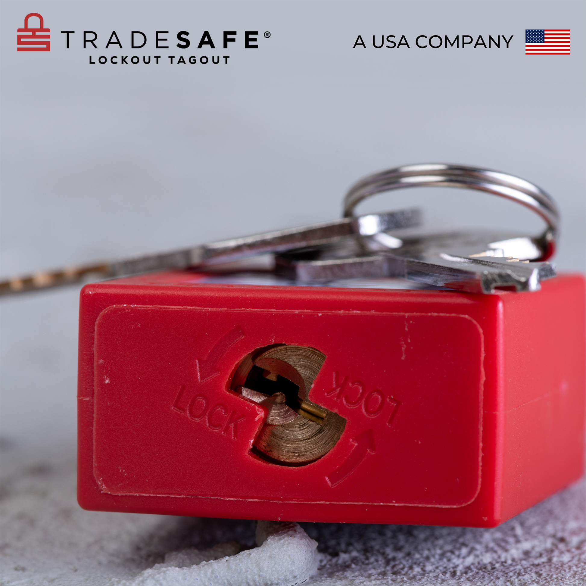 close-up view of the bottom part of a red loto padlock lying down in a concrete floor