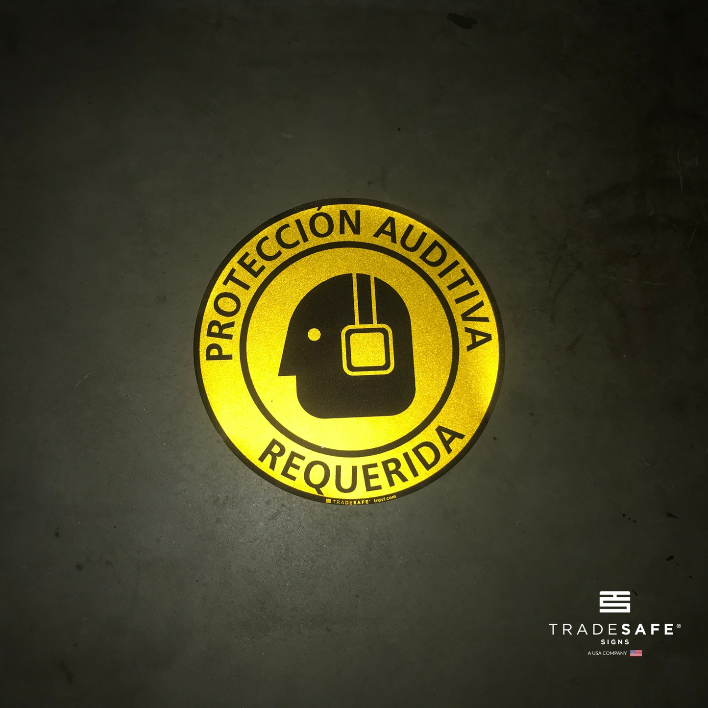 reflective attribute of adhesive vinyl "protección auditiva requerida" sign on black background