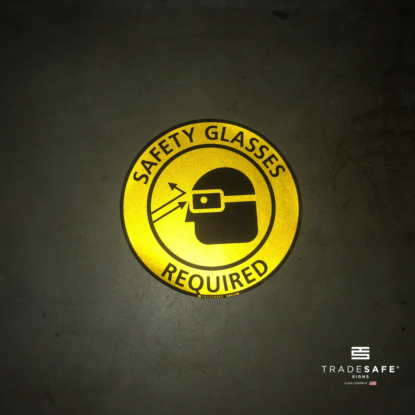 reflective attribute of adhesive vinyl "safety glasses required" sign on black background