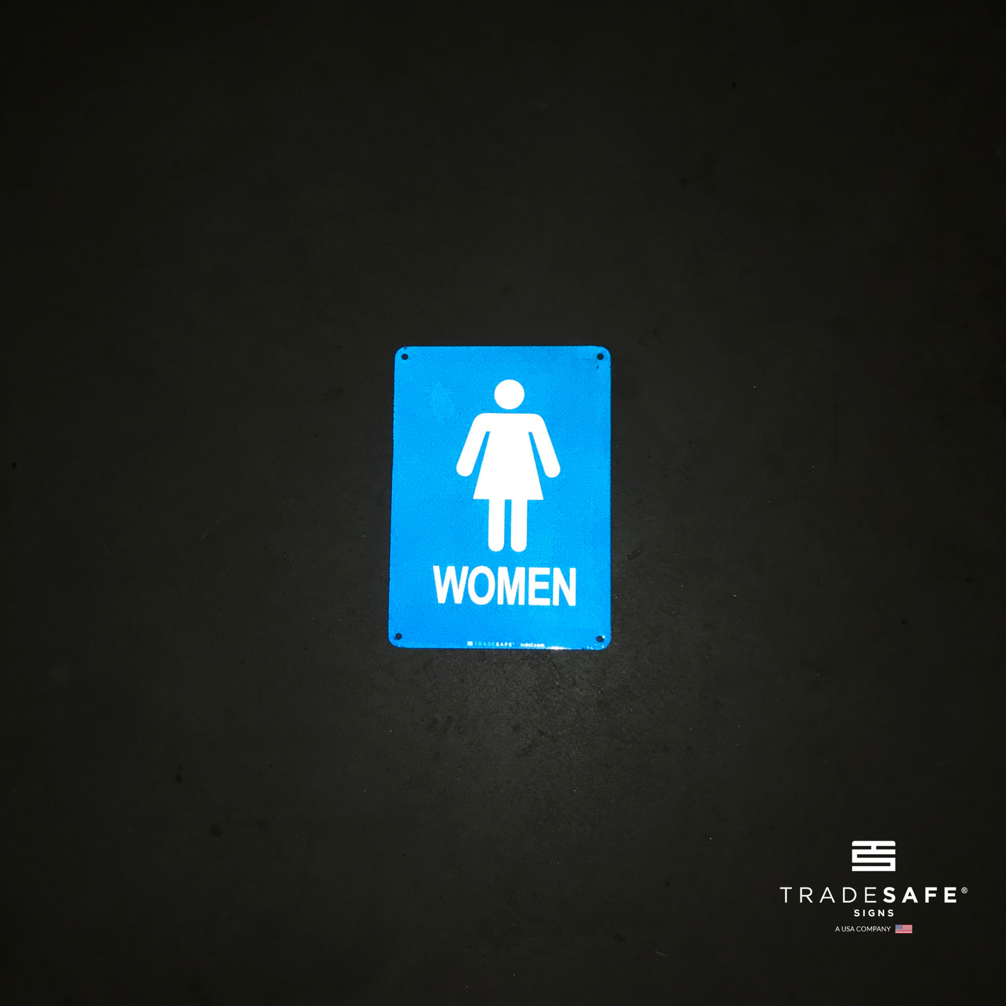 reflective attribute of women's restroom sign on black background