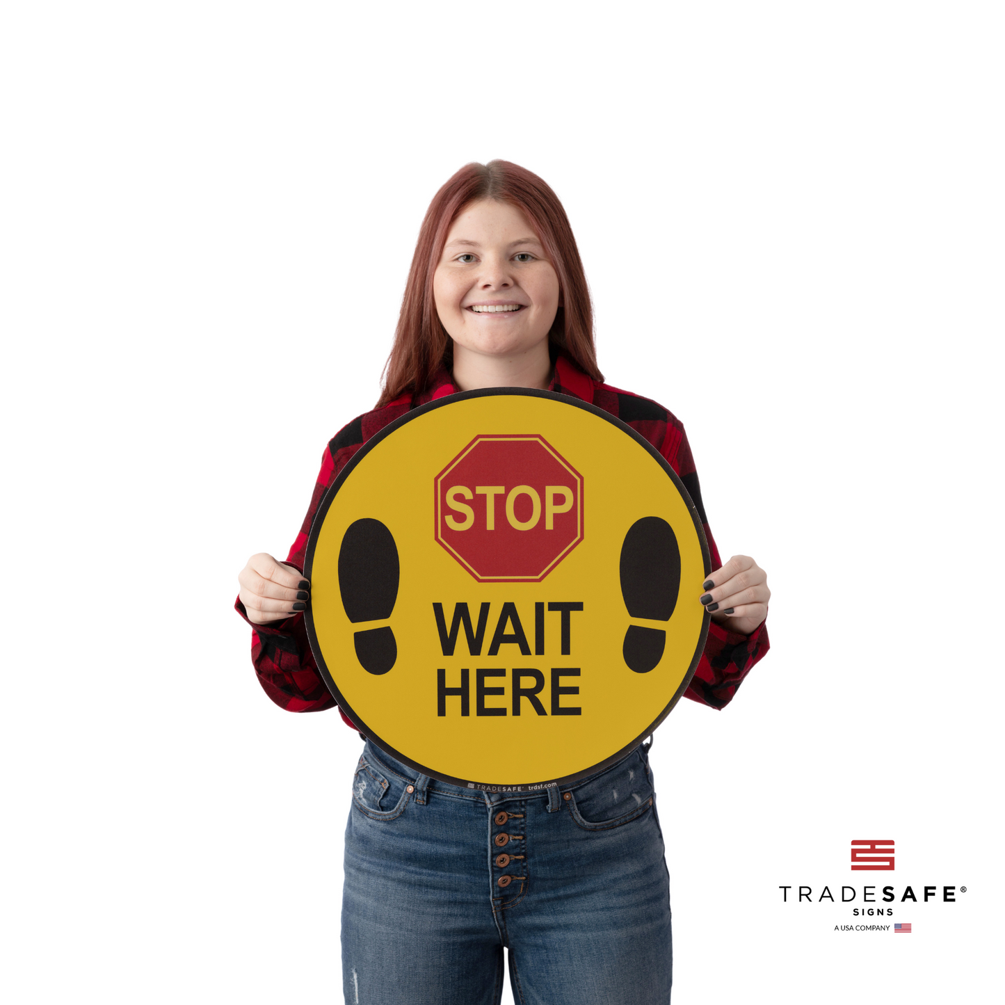 a person holding an adhesive vinyl sign with the text "stop wait here"